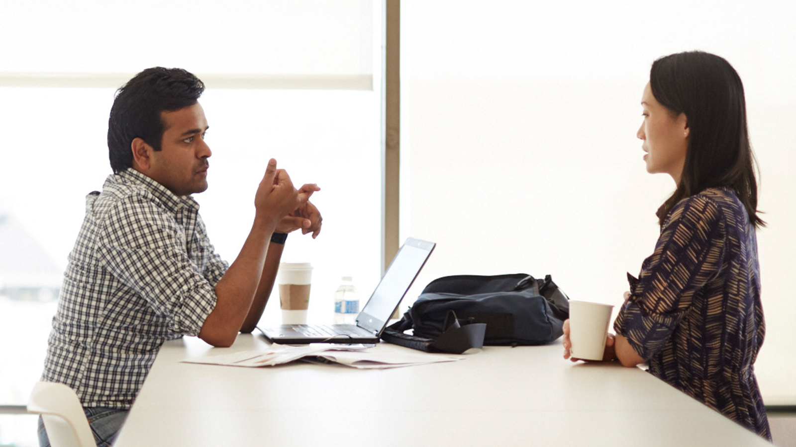 A man and a woman sitting at a table and having a conversation. A man and a woman sitting at a table and having a conversation.