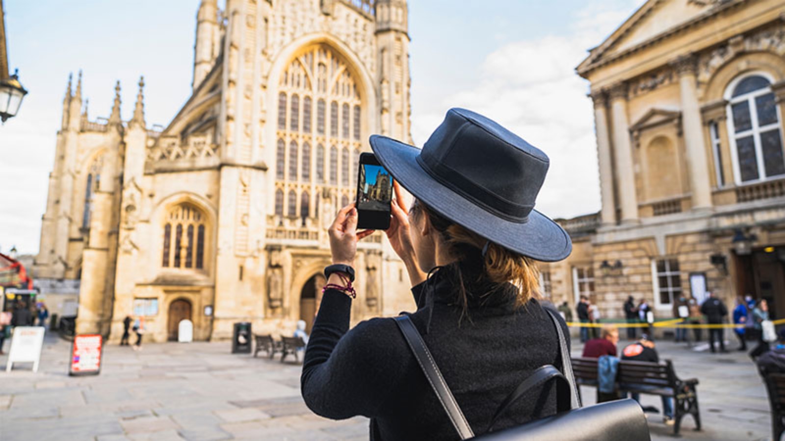 tourist taking picture on phone in city of bath